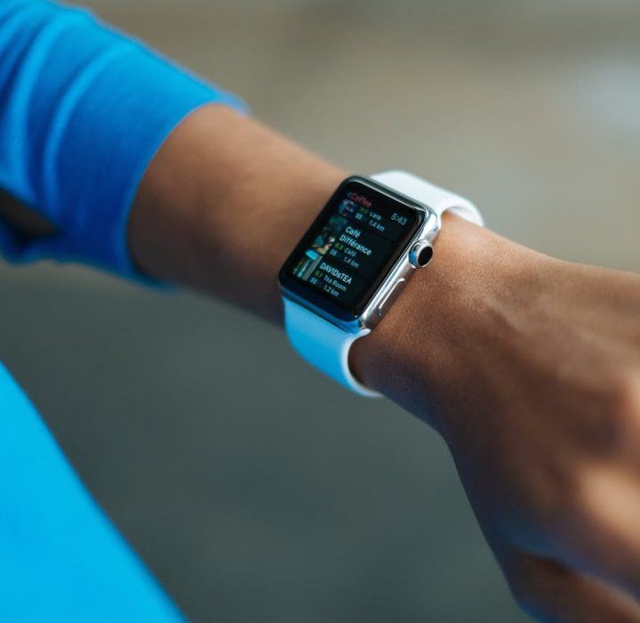 Focus on a smartwatch worn on an adult's wrist, showcasing its digital display.